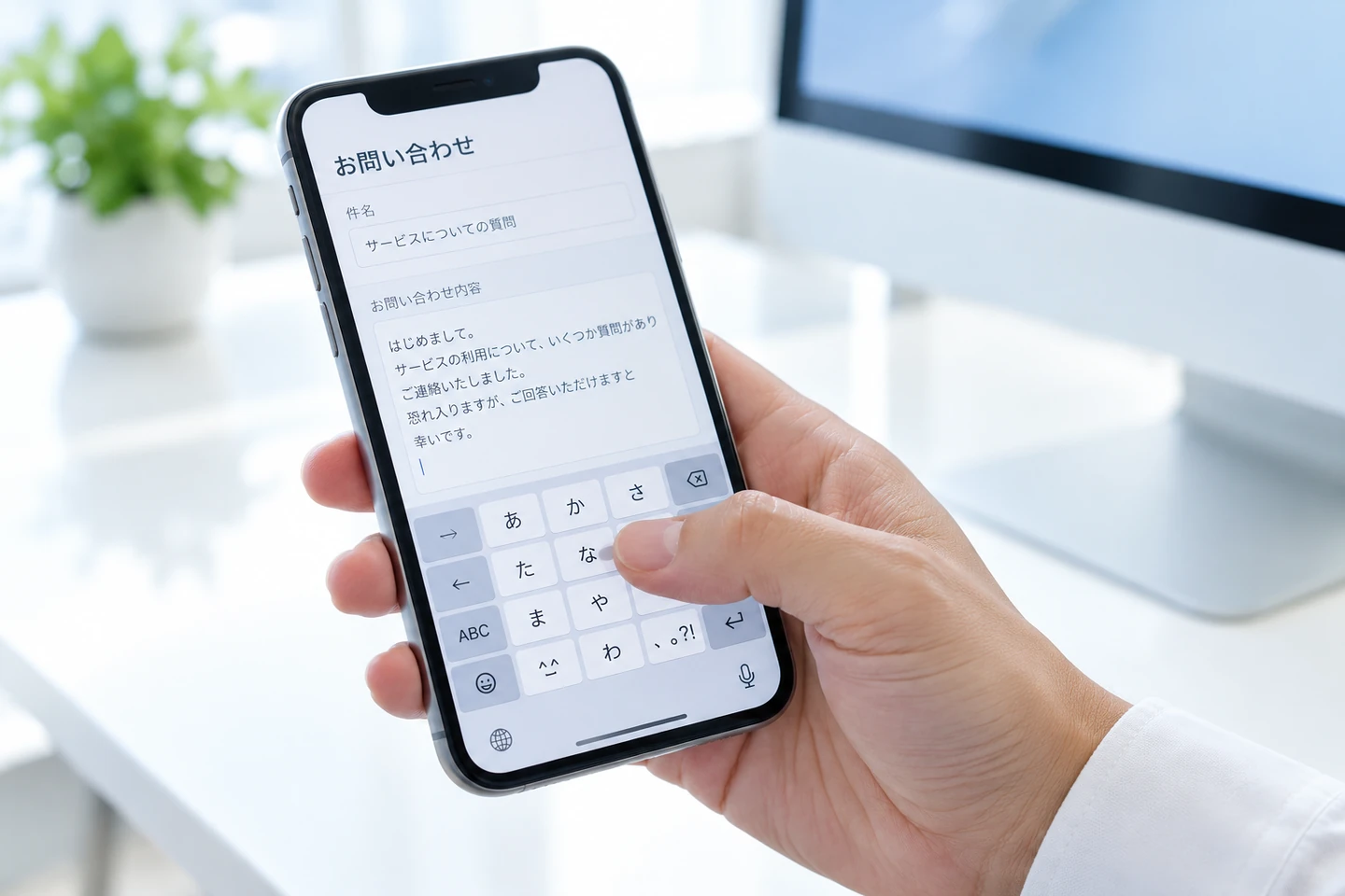 スマートフォンの画面に問い合わせ内容を入力する手元のイメージ